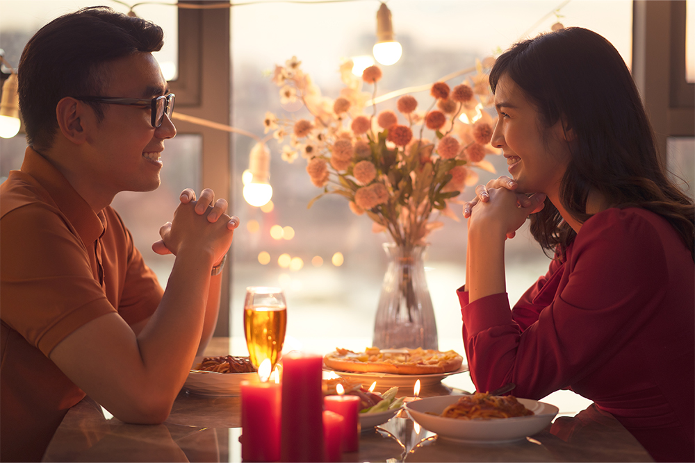 Couple celebrating Valentines' Day with flowers and food